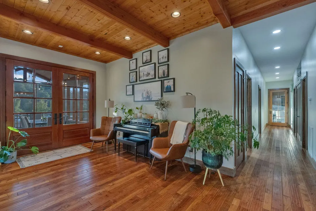 180 Riverwalk Court Home in Greeneville, Tennessee. Discover your dream oasis on this breathtaking 5-acre riverfront property! This extraordinary 7,000+ sqft home seamlessly blends transitional architecture with rustic charm, creating a captivating retreat. The striking blend of stone and poplar wood siding on the exterior exudes warmth and charm.