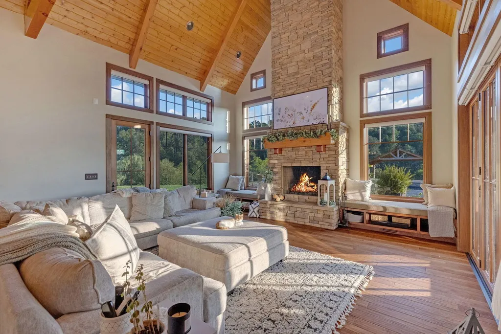 180 Riverwalk Court Home in Greeneville, Tennessee. Discover your dream oasis on this breathtaking 5-acre riverfront property! This extraordinary 7,000+ sqft home seamlessly blends transitional architecture with rustic charm, creating a captivating retreat. The striking blend of stone and poplar wood siding on the exterior exudes warmth and charm.