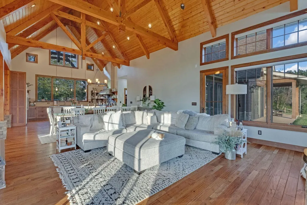 180 Riverwalk Court Home in Greeneville, Tennessee. Discover your dream oasis on this breathtaking 5-acre riverfront property! This extraordinary 7,000+ sqft home seamlessly blends transitional architecture with rustic charm, creating a captivating retreat. The striking blend of stone and poplar wood siding on the exterior exudes warmth and charm.