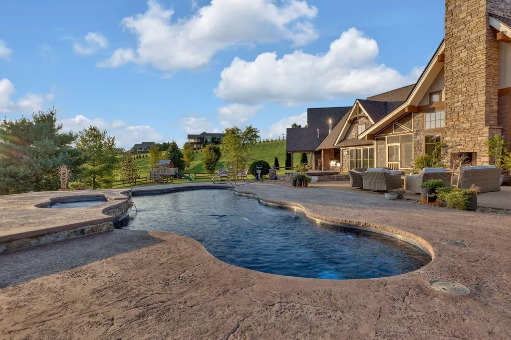 180 Riverwalk Court Home in Greeneville, Tennessee. Discover your dream oasis on this breathtaking 5-acre riverfront property! This extraordinary 7,000+ sqft home seamlessly blends transitional architecture with rustic charm, creating a captivating retreat. The striking blend of stone and poplar wood siding on the exterior exudes warmth and charm.