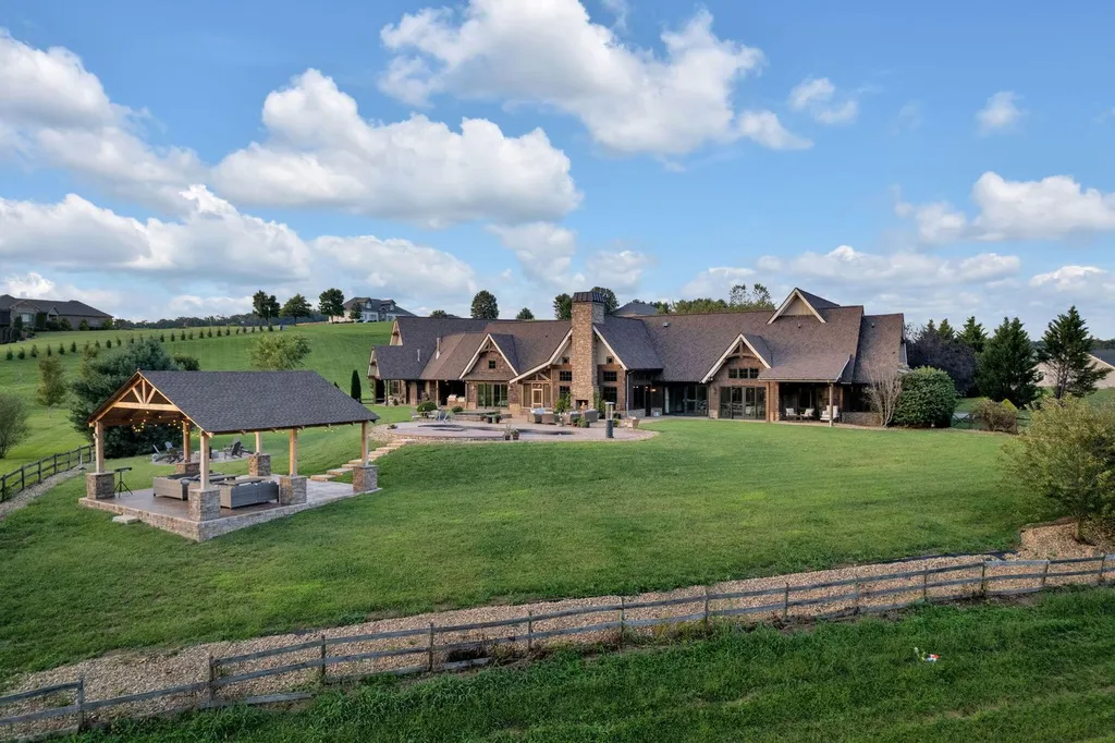 180 Riverwalk Court Home in Greeneville, Tennessee. Discover your dream oasis on this breathtaking 5-acre riverfront property! This extraordinary 7,000+ sqft home seamlessly blends transitional architecture with rustic charm, creating a captivating retreat. The striking blend of stone and poplar wood siding on the exterior exudes warmth and charm.