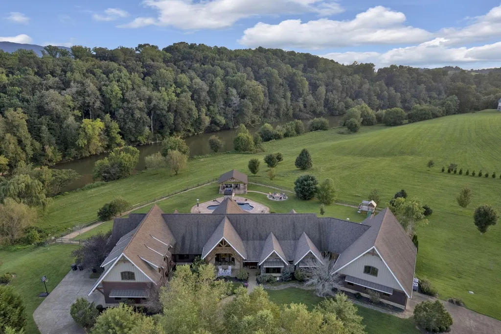 180 Riverwalk Court Home in Greeneville, Tennessee. Discover your dream oasis on this breathtaking 5-acre riverfront property! This extraordinary 7,000+ sqft home seamlessly blends transitional architecture with rustic charm, creating a captivating retreat. The striking blend of stone and poplar wood siding on the exterior exudes warmth and charm.