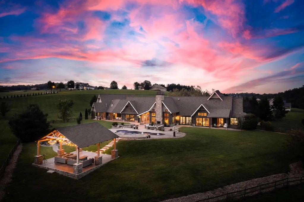 180 Riverwalk Court Home in Greeneville, Tennessee. Discover your dream oasis on this breathtaking 5-acre riverfront property! This extraordinary 7,000+ sqft home seamlessly blends transitional architecture with rustic charm, creating a captivating retreat. The striking blend of stone and poplar wood siding on the exterior exudes warmth and charm.