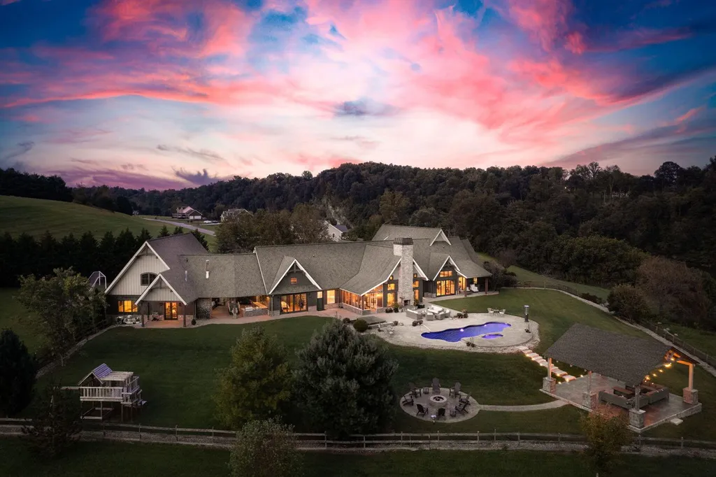 180 Riverwalk Court Home in Greeneville, Tennessee. Discover your dream oasis on this breathtaking 5-acre riverfront property! This extraordinary 7,000+ sqft home seamlessly blends transitional architecture with rustic charm, creating a captivating retreat. The striking blend of stone and poplar wood siding on the exterior exudes warmth and charm.