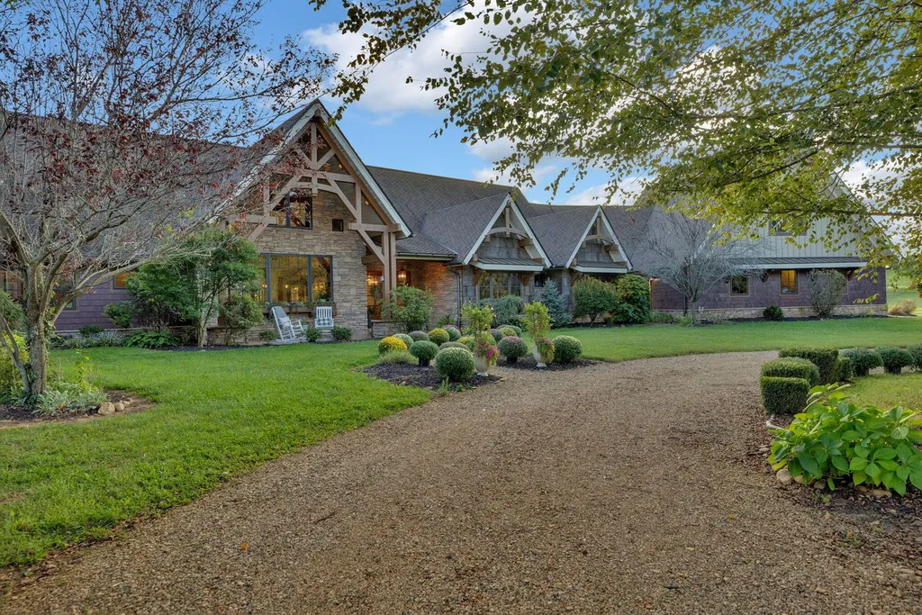 180 Riverwalk Court Home in Greeneville, Tennessee. Discover your dream oasis on this breathtaking 5-acre riverfront property! This extraordinary 7,000+ sqft home seamlessly blends transitional architecture with rustic charm, creating a captivating retreat. The striking blend of stone and poplar wood siding on the exterior exudes warmth and charm.
