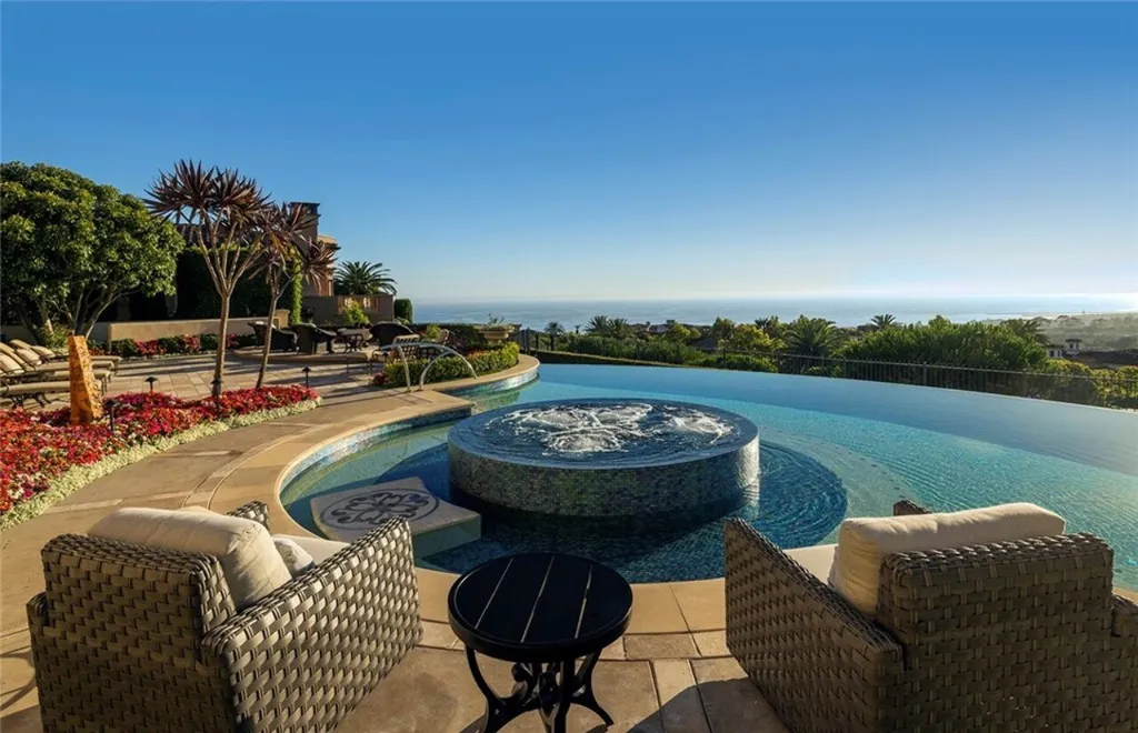5 Pelicans Drive Home in Newport Coast, California. This stunning Pelican Crest estate is ideally located on one of the most coveted prime view lots in the community. It offers luxury and elegance along with warm and inviting living. The property has 6 bedrooms, 6.5 bathrooms, and a spacious floor plan that is perfect for both intimate living and entertaining. It also features stunning ocean views, a state-of-the-art theater, and a wine cellar.