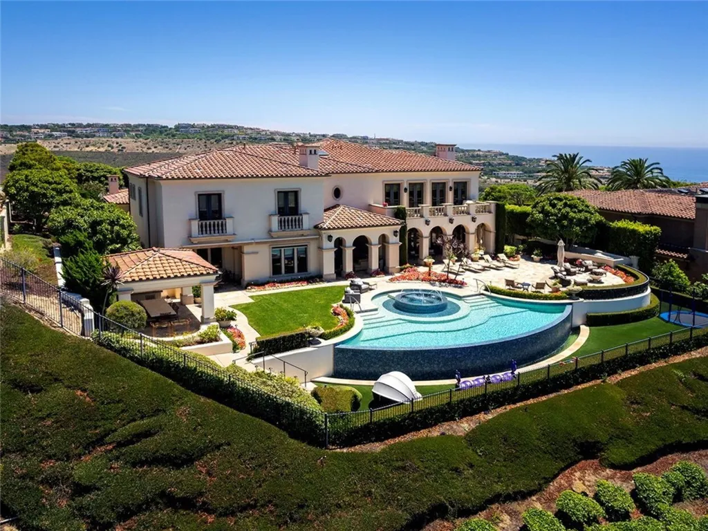 5 Pelicans Drive Home in Newport Coast, California. This stunning Pelican Crest estate is ideally located on one of the most coveted prime view lots in the community. It offers luxury and elegance along with warm and inviting living. The property has 6 bedrooms, 6.5 bathrooms, and a spacious floor plan that is perfect for both intimate living and entertaining. It also features stunning ocean views, a state-of-the-art theater, and a wine cellar.