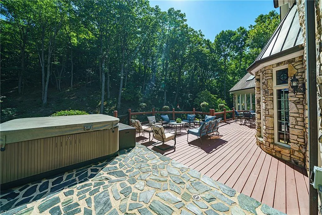 5712 Summit Road Home in Purlear, North Carolina. Explore this exceptional 128+ acre mountain retreat with a gated entrance, a timber-frame home boasting 5 bedrooms and 5 bathrooms. Enjoy the beauty of two spring-fed creeks that encircle the fieldstone exterior of the home.