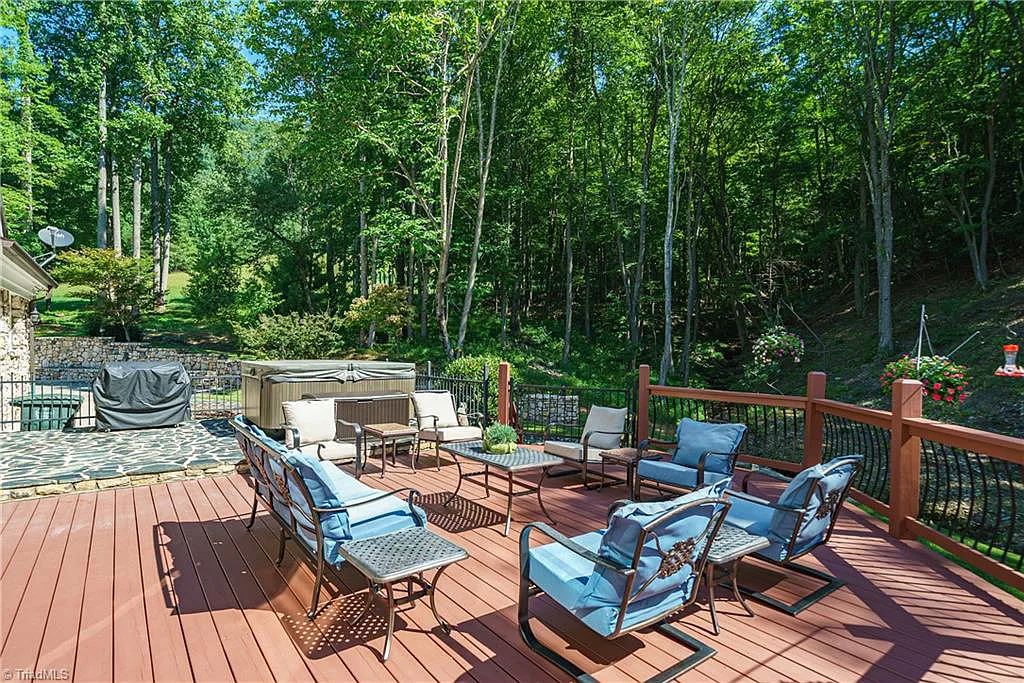5712 Summit Road Home in Purlear, North Carolina. Explore this exceptional 128+ acre mountain retreat with a gated entrance, a timber-frame home boasting 5 bedrooms and 5 bathrooms. Enjoy the beauty of two spring-fed creeks that encircle the fieldstone exterior of the home.