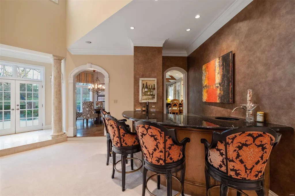 8 Lochinvar Drive Home in Saint Louis, Missouri. This stunning custom built home features a cascading waterfall, spacious living areas, and a finished lower level with every amenity. It is perfect for everyday living and entertaining.