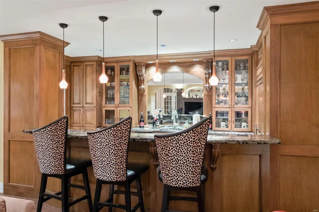 8 Lochinvar Drive Home in Saint Louis, Missouri. This stunning custom built home features a cascading waterfall, spacious living areas, and a finished lower level with every amenity. It is perfect for everyday living and entertaining.