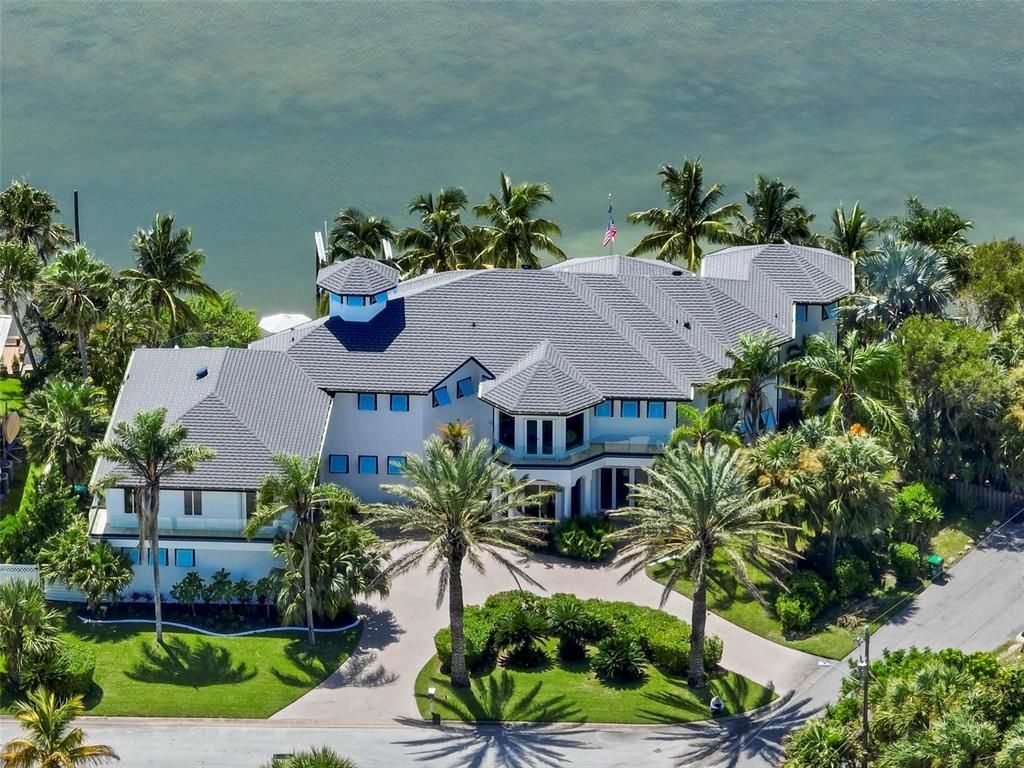 Discover the epitome of luxury living at 2 River Falls Drive, Cocoa Beach, Florida. This 5-bedroom, 6-bathroom custom estate, fully remodeled in 2022, offers 150 feet of pristine river frontage and unobstructed views.