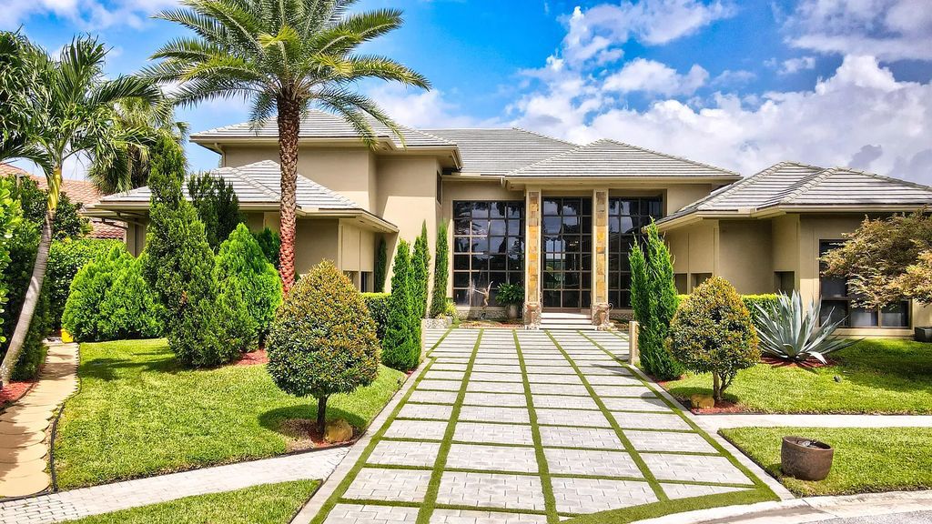 Welcome to 17999 Lake Estates Dr, Boca Raton, Florida, a Frank Lloyd Wright-inspired masterpiece that seamlessly marries modern luxury with natural beauty and advanced technology. This extraordinary estate greets you with dramatic two-story architecture and a 23-foot glass wall offering stunning views of the infinity pool, the sprawling lake, and the golf course.