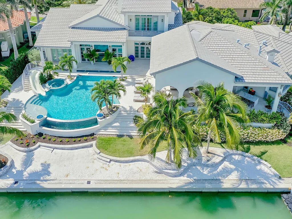 Discover your dream home at 1340 Caxambas Ct, Marco Island, Florida! This 5-bed, 5-bath luxury residence with a theater room boasts 5,007 sq ft of impeccable craftsmanship, situated on 0.59 acres with 248 ft of water frontage and a newer seawall, ensuring endless views and quick access to Caxambas Pass.