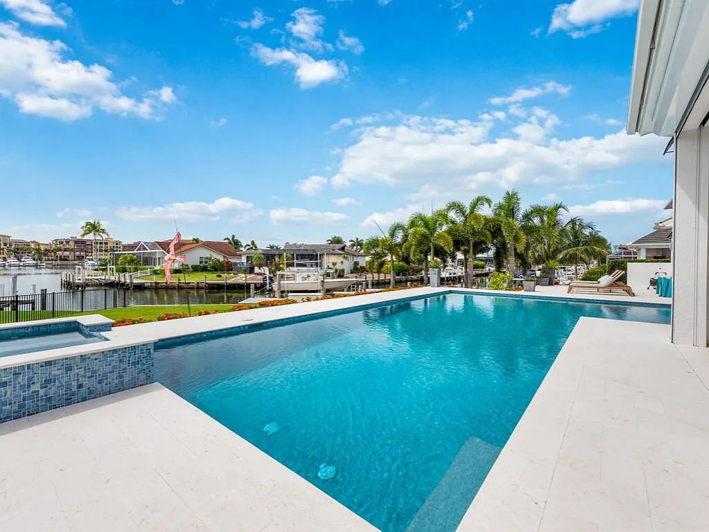 Discover waterfront perfection at 681 Crescent St, Marco Island, FL. This 2020-built, lightly lived-in masterpiece offers 4 bedrooms, 5 baths, and 4,047 square feet of luxury living. Its open split floor plan seamlessly blends indoor and outdoor spaces, revealing breathtaking bay views.