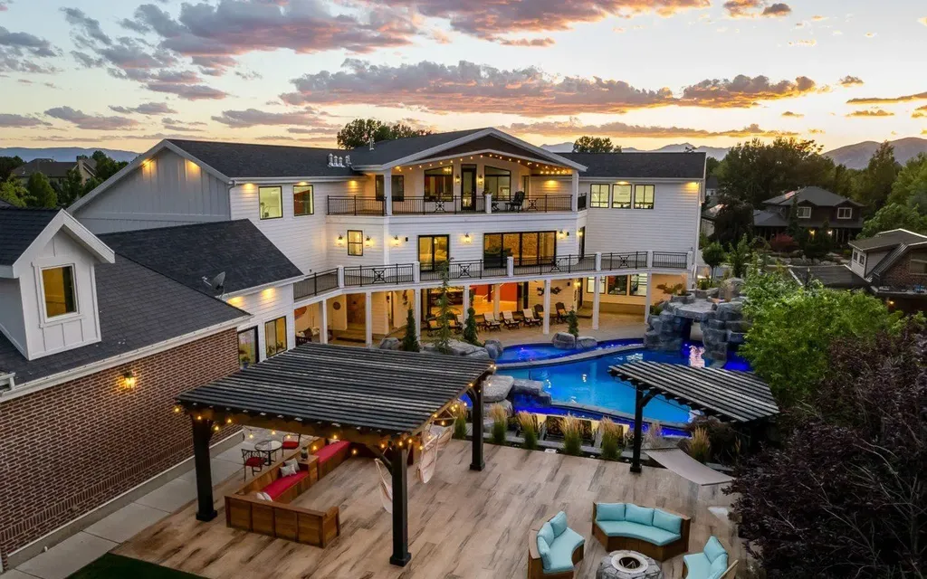 1263 East Chapman Court Home in Alpine, Utah. Step into the lap of luxury in this expansive 13,000 sq ft home in Alpine, Utah. With 8 oversized bedrooms, 6 bathrooms, a 13-car garage, and an outdoor entertainment paradise featuring a pool, spa, and lush landscaping, this property is perfect for hosting and living in grand style.