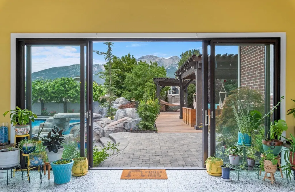 1263 East Chapman Court Home in Alpine, Utah. Step into the lap of luxury in this expansive 13,000 sq ft home in Alpine, Utah. With 8 oversized bedrooms, 6 bathrooms, a 13-car garage, and an outdoor entertainment paradise featuring a pool, spa, and lush landscaping, this property is perfect for hosting and living in grand style.