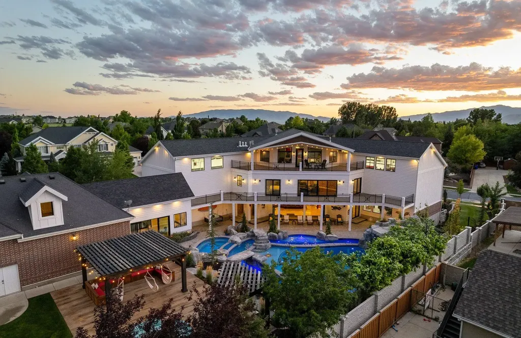 1263 East Chapman Court Home in Alpine, Utah. Step into the lap of luxury in this expansive 13,000 sq ft home in Alpine, Utah. With 8 oversized bedrooms, 6 bathrooms, a 13-car garage, and an outdoor entertainment paradise featuring a pool, spa, and lush landscaping, this property is perfect for hosting and living in grand style.