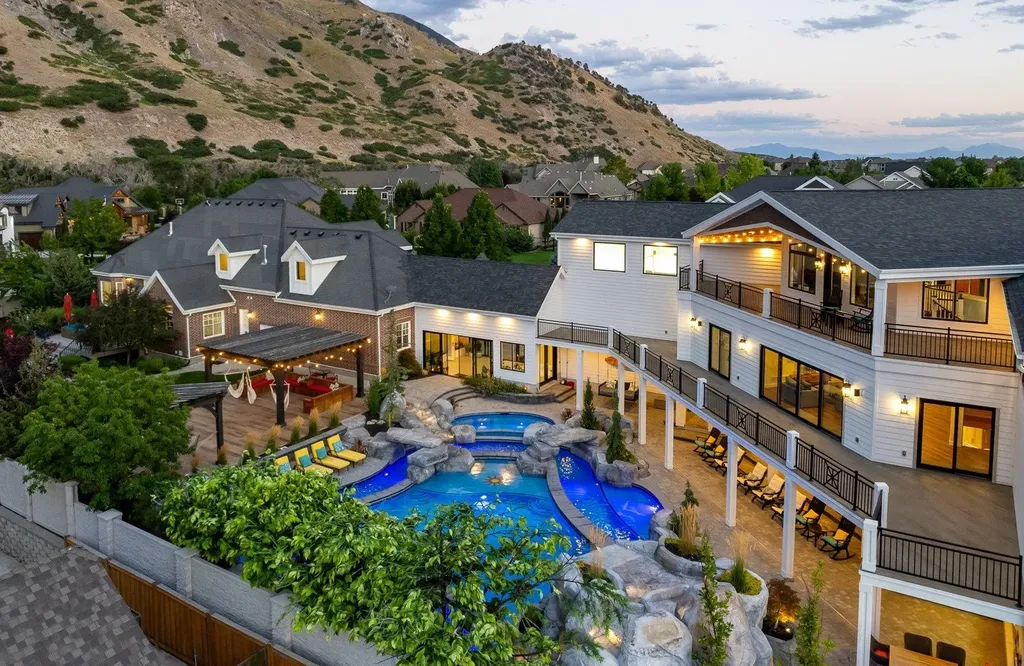 1263 East Chapman Court Home in Alpine, Utah. Step into the lap of luxury in this expansive 13,000 sq ft home in Alpine, Utah. With 8 oversized bedrooms, 6 bathrooms, a 13-car garage, and an outdoor entertainment paradise featuring a pool, spa, and lush landscaping, this property is perfect for hosting and living in grand style.