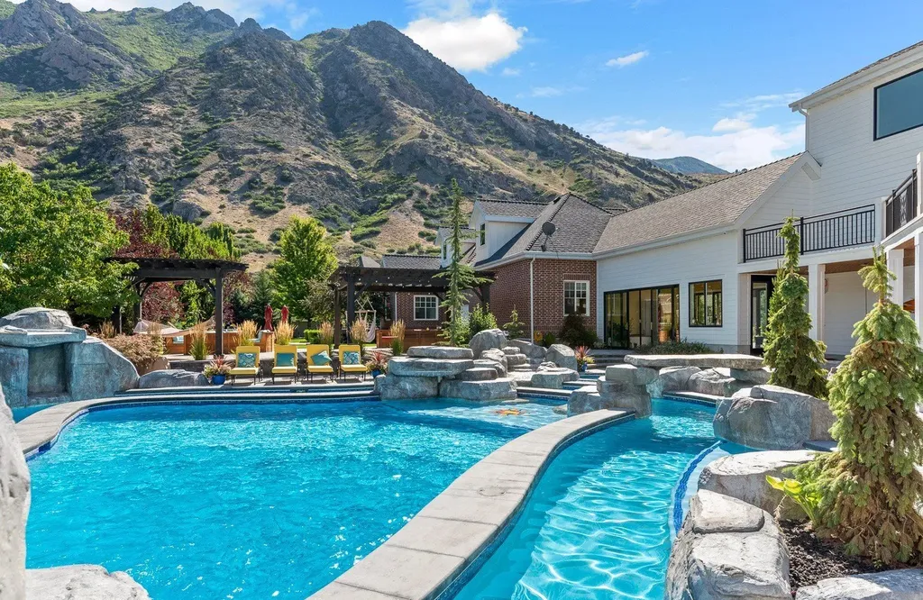 1263 East Chapman Court Home in Alpine, Utah. Step into the lap of luxury in this expansive 13,000 sq ft home in Alpine, Utah. With 8 oversized bedrooms, 6 bathrooms, a 13-car garage, and an outdoor entertainment paradise featuring a pool, spa, and lush landscaping, this property is perfect for hosting and living in grand style.