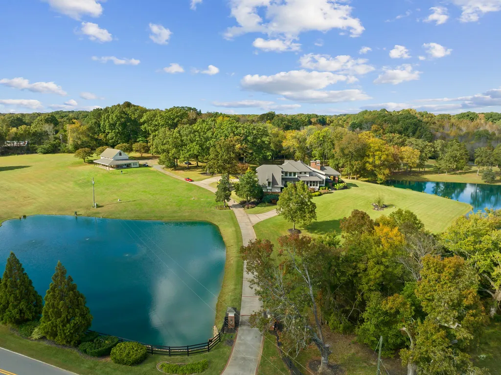 13500 Cabarrus Station Road Home in Midland, North Carolina. Experience the epitome of country living at Clover Lake, an architecturally designed estate on over 30 acres of rolling pastures, serene ponds, and private outdoor spaces just 35 minutes from Uptown Charlotte. This exceptional property features a 3-car garage, gated entry, gourmet kitchen, spacious bedrooms with en-suite baths, and a 4-stall horse barn with a shop, tack room, and office.