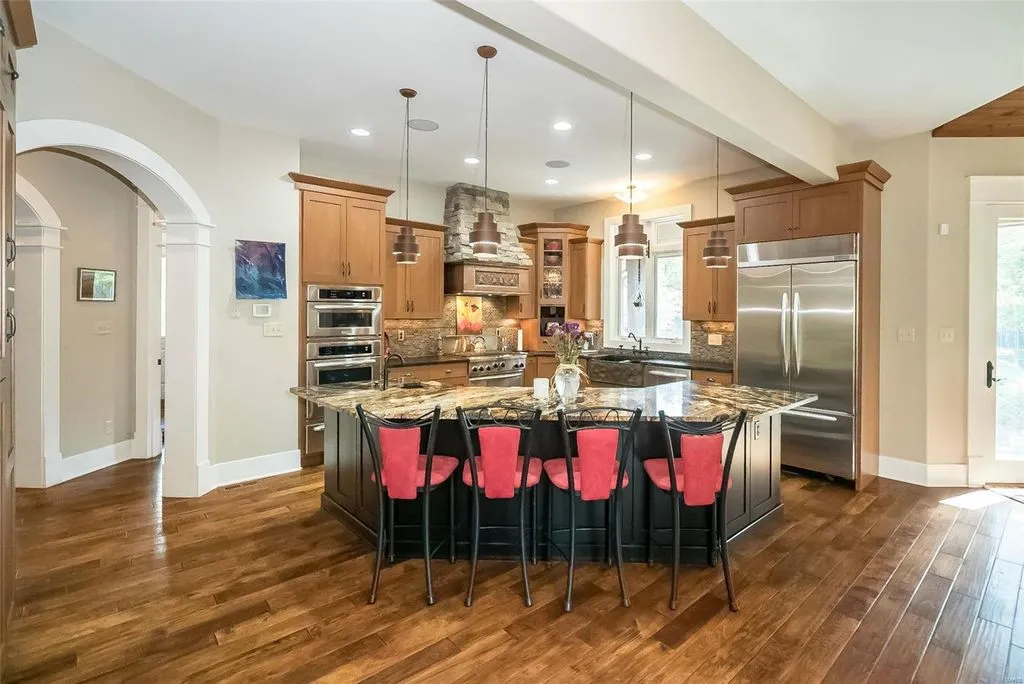 1377 South Mason Road Home in Saint Louis, Missouri. Discover this remarkable 3.3-acre estate bordering Queeny Park, boasting an array of extraordinary outdoor amenities and unmatched privacy. With a massive 2-story foyer, designer kitchen, primary suite with a see-through fireplace, and a sprawling lower level featuring a rec room, theatre, gym, and more. 