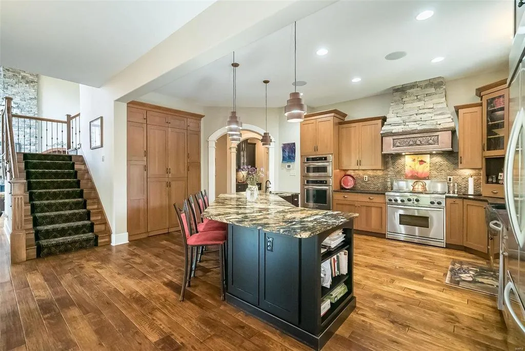 1377 South Mason Road Home in Saint Louis, Missouri. Discover this remarkable 3.3-acre estate bordering Queeny Park, boasting an array of extraordinary outdoor amenities and unmatched privacy. With a massive 2-story foyer, designer kitchen, primary suite with a see-through fireplace, and a sprawling lower level featuring a rec room, theatre, gym, and more. 