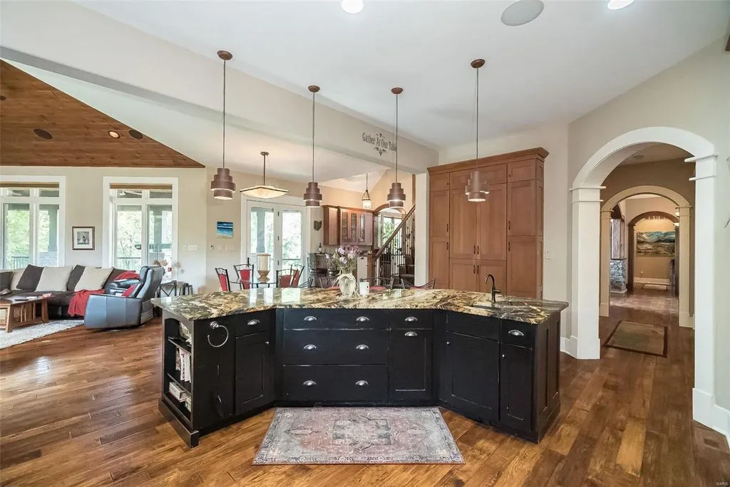 1377 South Mason Road Home in Saint Louis, Missouri. Discover this remarkable 3.3-acre estate bordering Queeny Park, boasting an array of extraordinary outdoor amenities and unmatched privacy. With a massive 2-story foyer, designer kitchen, primary suite with a see-through fireplace, and a sprawling lower level featuring a rec room, theatre, gym, and more. 
