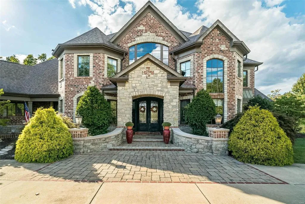 1377 South Mason Road Home in Saint Louis, Missouri. Discover this remarkable 3.3-acre estate bordering Queeny Park, boasting an array of extraordinary outdoor amenities and unmatched privacy. With a massive 2-story foyer, designer kitchen, primary suite with a see-through fireplace, and a sprawling lower level featuring a rec room, theatre, gym, and more. 