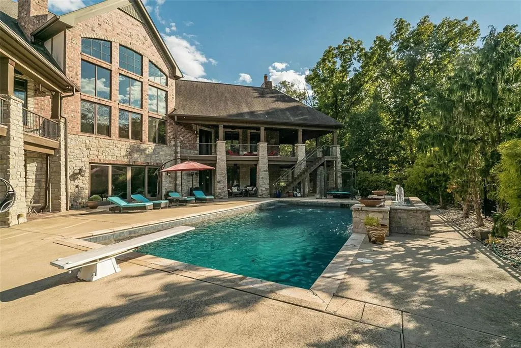 1377 South Mason Road Home in Saint Louis, Missouri. Discover this remarkable 3.3-acre estate bordering Queeny Park, boasting an array of extraordinary outdoor amenities and unmatched privacy. With a massive 2-story foyer, designer kitchen, primary suite with a see-through fireplace, and a sprawling lower level featuring a rec room, theatre, gym, and more. 