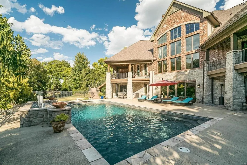 1377 South Mason Road Home in Saint Louis, Missouri. Discover this remarkable 3.3-acre estate bordering Queeny Park, boasting an array of extraordinary outdoor amenities and unmatched privacy. With a massive 2-story foyer, designer kitchen, primary suite with a see-through fireplace, and a sprawling lower level featuring a rec room, theatre, gym, and more. 