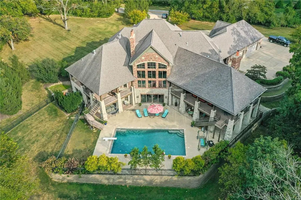 1377 South Mason Road Home in Saint Louis, Missouri. Discover this remarkable 3.3-acre estate bordering Queeny Park, boasting an array of extraordinary outdoor amenities and unmatched privacy. With a massive 2-story foyer, designer kitchen, primary suite with a see-through fireplace, and a sprawling lower level featuring a rec room, theatre, gym, and more. 