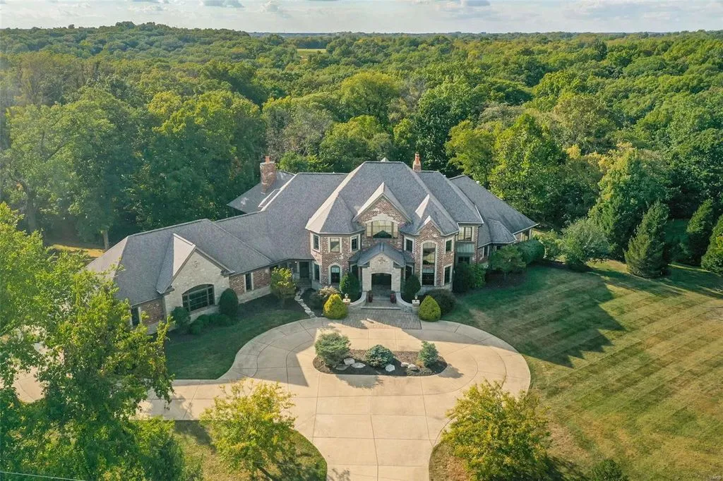 1377 South Mason Road Home in Saint Louis, Missouri. Discover this remarkable 3.3-acre estate bordering Queeny Park, boasting an array of extraordinary outdoor amenities and unmatched privacy. With a massive 2-story foyer, designer kitchen, primary suite with a see-through fireplace, and a sprawling lower level featuring a rec room, theatre, gym, and more. 
