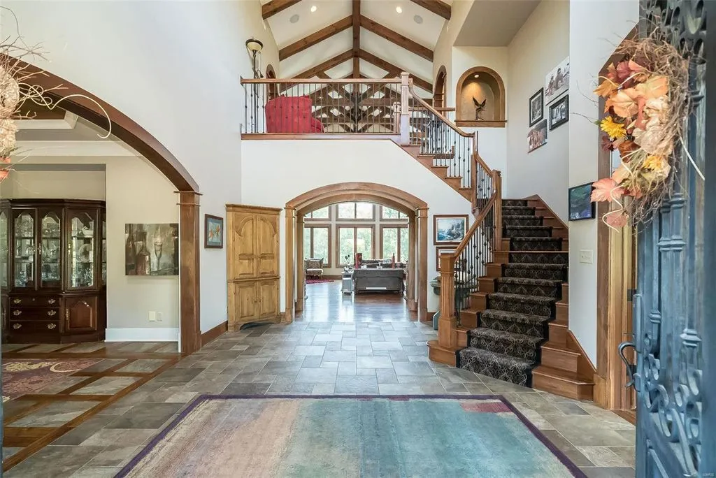 1377 South Mason Road Home in Saint Louis, Missouri. Discover this remarkable 3.3-acre estate bordering Queeny Park, boasting an array of extraordinary outdoor amenities and unmatched privacy. With a massive 2-story foyer, designer kitchen, primary suite with a see-through fireplace, and a sprawling lower level featuring a rec room, theatre, gym, and more. 