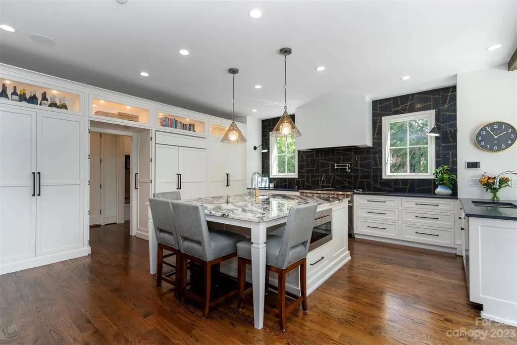 2215 Cortelyou Road Home in Charlotte, North Carolina. Discover the epitome of luxury living in this South Park masterpiece featuring 6 spacious bedrooms, 5 full and 2 half bathrooms, and exquisite craftsmanship throughout. Chef's dream kitchen, a stunning primary suite, media room, sauna, and resort-style outdoor amenities, including a custom pool and outdoor kitchen.