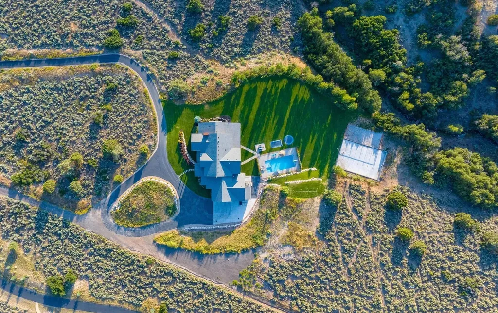 4115 Greener Hills Drive Home in Heber, Utah. Discover a 7.55-acre gated estate in Greener Hills. This luxury property features remarkable entertainment amenities, from exposed wood beams to a gourmet kitchen with Wolf appliances, an outdoor kitchen, pool, and firepit. The main level master offers radiant heat flooring, and the estate includes a playhouse, home theater, and more.