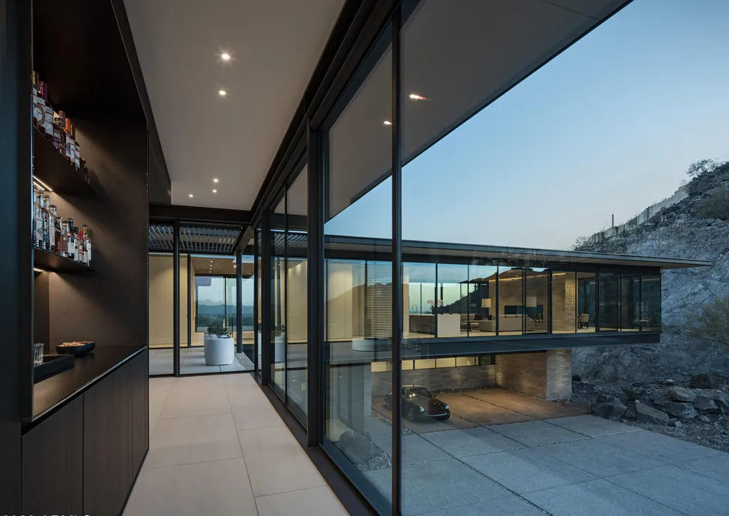 4301 E Upper Ridge Way Home in Paradise Valley, Arizona. Perched between two mountain peaks, the Upper Ridge Residence is an 8,000+ sf modern marvel designed by The Construction Zone. Featuring panoramic Valley of the Sun views, this steel and glass pavilion offers the highest level of craftsmanship.