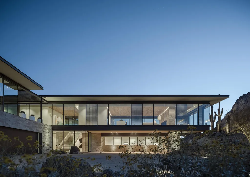 4301 E Upper Ridge Way Home in Paradise Valley, Arizona. Perched between two mountain peaks, the Upper Ridge Residence is an 8,000+ sf modern marvel designed by The Construction Zone. Featuring panoramic Valley of the Sun views, this steel and glass pavilion offers the highest level of craftsmanship.