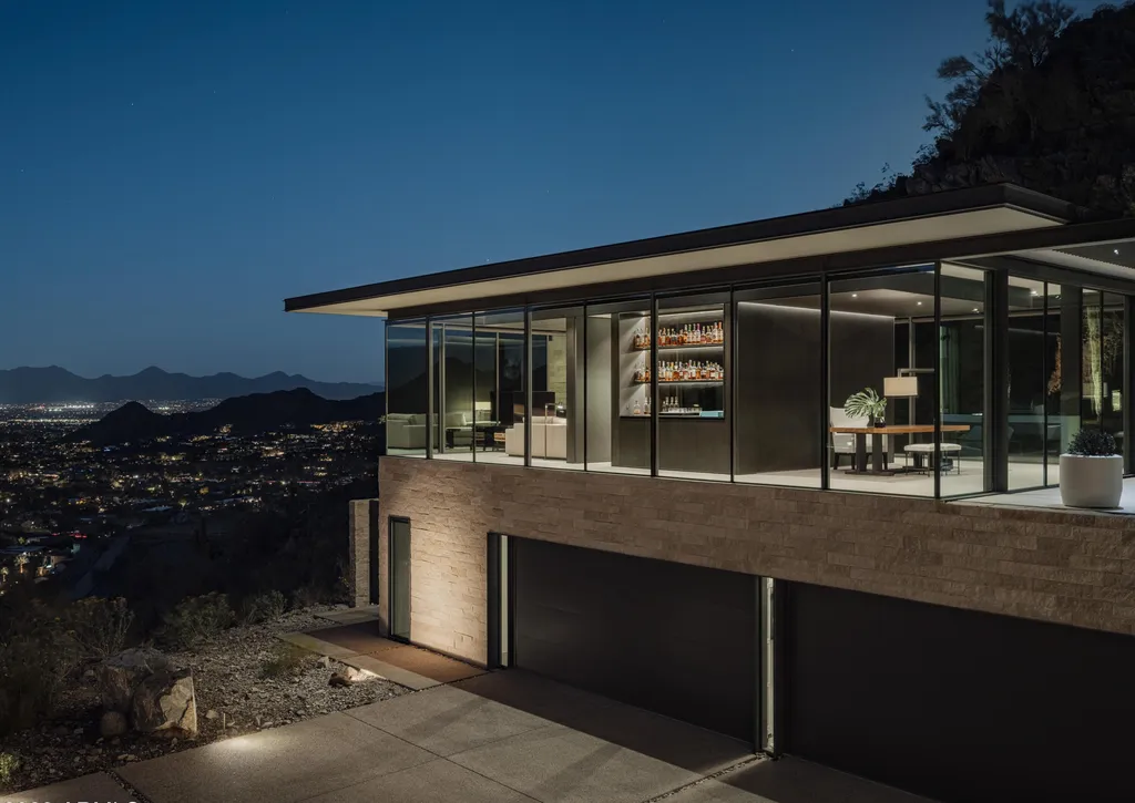 4301 E Upper Ridge Way Home in Paradise Valley, Arizona. Perched between two mountain peaks, the Upper Ridge Residence is an 8,000+ sf modern marvel designed by The Construction Zone. Featuring panoramic Valley of the Sun views, this steel and glass pavilion offers the highest level of craftsmanship.
