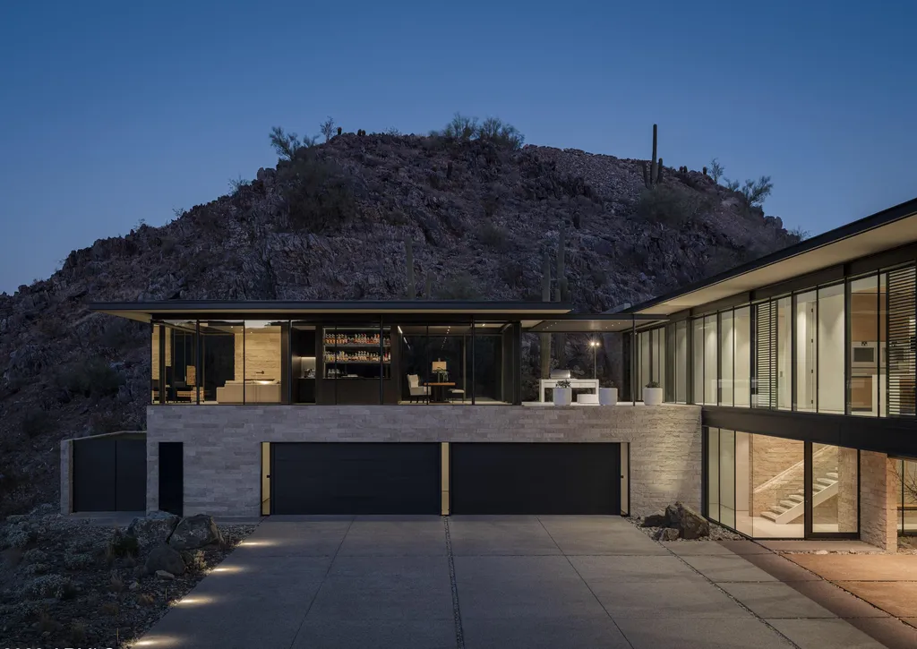 4301 E Upper Ridge Way Home in Paradise Valley, Arizona. Perched between two mountain peaks, the Upper Ridge Residence is an 8,000+ sf modern marvel designed by The Construction Zone. Featuring panoramic Valley of the Sun views, this steel and glass pavilion offers the highest level of craftsmanship.