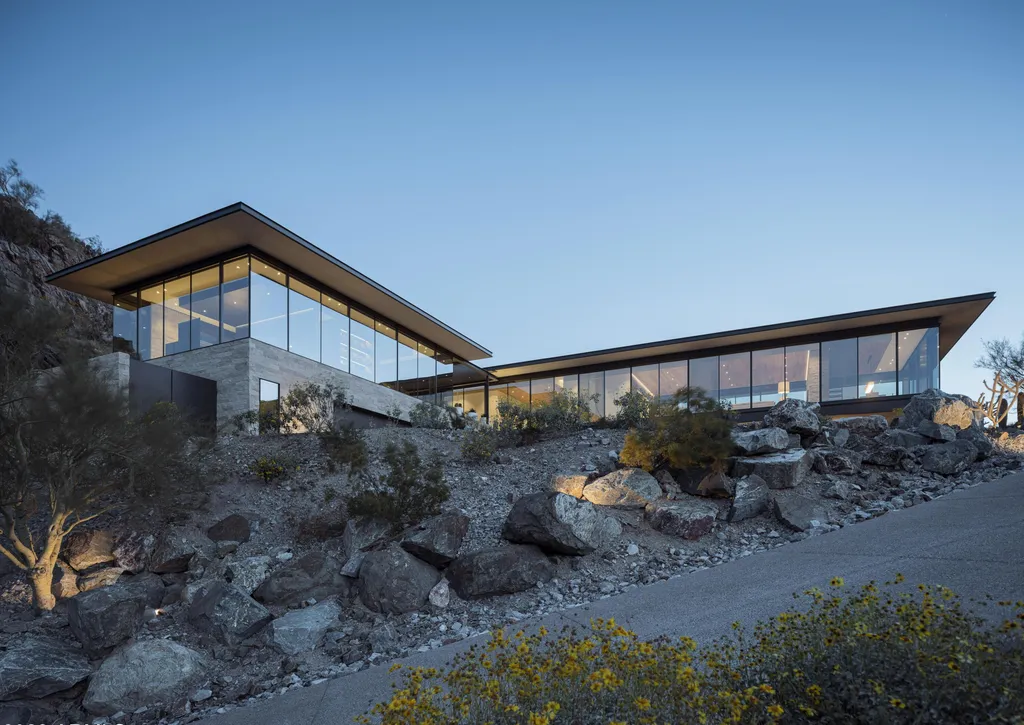 4301 E Upper Ridge Way Home in Paradise Valley, Arizona. Perched between two mountain peaks, the Upper Ridge Residence is an 8,000+ sf modern marvel designed by The Construction Zone. Featuring panoramic Valley of the Sun views, this steel and glass pavilion offers the highest level of craftsmanship.