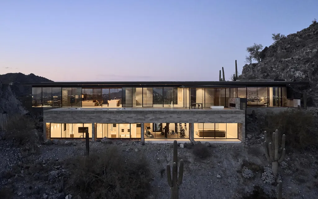 4301 E Upper Ridge Way Home in Paradise Valley, Arizona. Perched between two mountain peaks, the Upper Ridge Residence is an 8,000+ sf modern marvel designed by The Construction Zone. Featuring panoramic Valley of the Sun views, this steel and glass pavilion offers the highest level of craftsmanship.