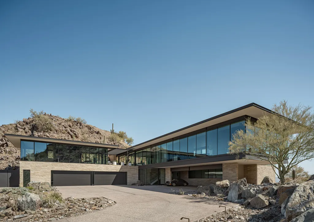 4301 E Upper Ridge Way Home in Paradise Valley, Arizona. Perched between two mountain peaks, the Upper Ridge Residence is an 8,000+ sf modern marvel designed by The Construction Zone. Featuring panoramic Valley of the Sun views, this steel and glass pavilion offers the highest level of craftsmanship.