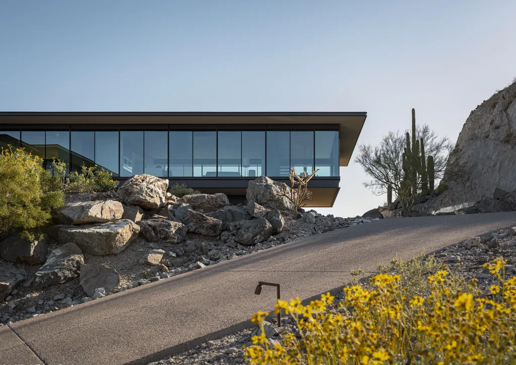 4301 E Upper Ridge Way Home in Paradise Valley, Arizona. Perched between two mountain peaks, the Upper Ridge Residence is an 8,000+ sf modern marvel designed by The Construction Zone. Featuring panoramic Valley of the Sun views, this steel and glass pavilion offers the highest level of craftsmanship.