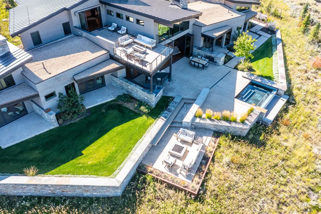 7235 North Starlight Circle Home in Kamas, Utah. Experience ultimate luxury living in this exceptional 5-bedroom, 5 ½-bathroom masterpiece spanning 6,270 square feet. Embrace the outdoors with folding glass doors leading to a heated patio, infinity spa pool, and landscaped yard with stunning Deer Valley and Jordanelle Reservoir views.
