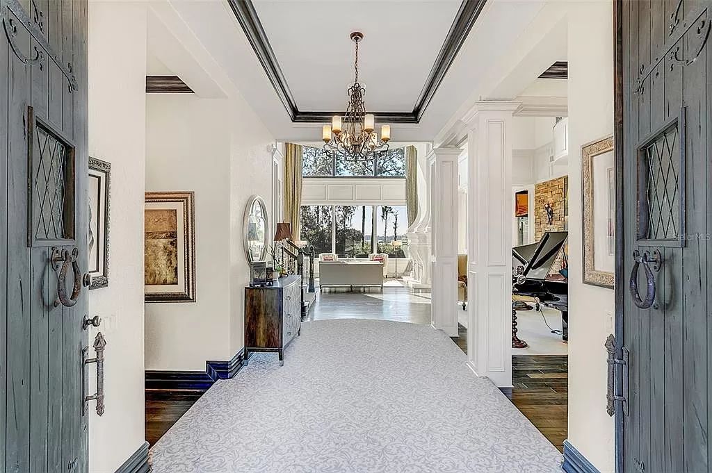 Situated within Windermere's exclusive community, this 10,485-square-foot estate at 6507 Rosella Ct embodies luxury living at its peak. Built by Stonebridge Custom Homes in 2007, the 7-bedroom, 8-bathroom property features an impressive array of amenities including a grand atrium with stunning lake views, a theater, two swimming pools, a spa, and an outdoor kitchen.