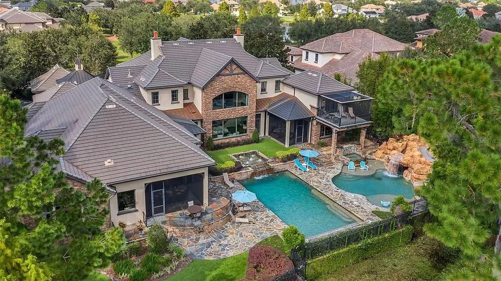 Situated within Windermere's exclusive community, this 10,485-square-foot estate at 6507 Rosella Ct embodies luxury living at its peak. Built by Stonebridge Custom Homes in 2007, the 7-bedroom, 8-bathroom property features an impressive array of amenities including a grand atrium with stunning lake views, a theater, two swimming pools, a spa, and an outdoor kitchen.