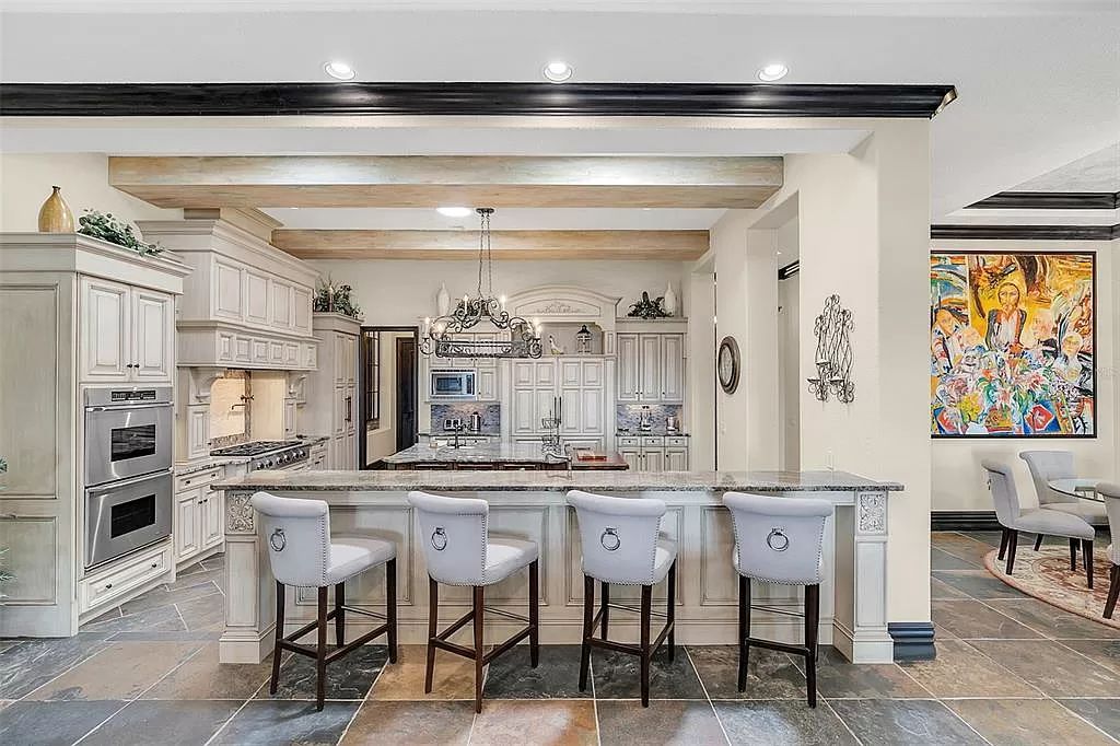 Situated within Windermere's exclusive community, this 10,485-square-foot estate at 6507 Rosella Ct embodies luxury living at its peak. Built by Stonebridge Custom Homes in 2007, the 7-bedroom, 8-bathroom property features an impressive array of amenities including a grand atrium with stunning lake views, a theater, two swimming pools, a spa, and an outdoor kitchen.