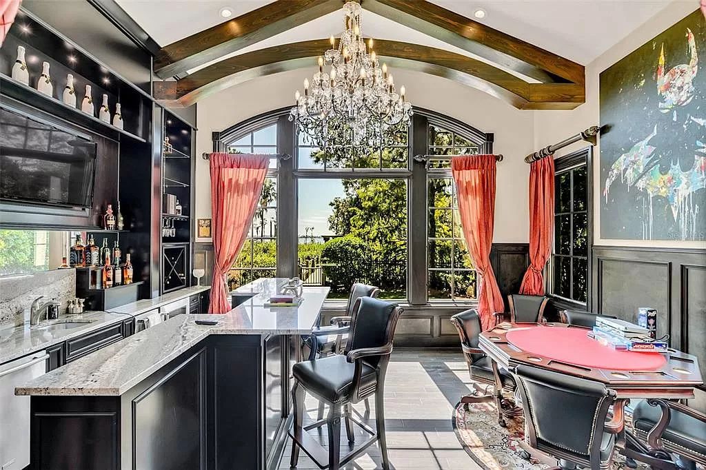 Situated within Windermere's exclusive community, this 10,485-square-foot estate at 6507 Rosella Ct embodies luxury living at its peak. Built by Stonebridge Custom Homes in 2007, the 7-bedroom, 8-bathroom property features an impressive array of amenities including a grand atrium with stunning lake views, a theater, two swimming pools, a spa, and an outdoor kitchen.