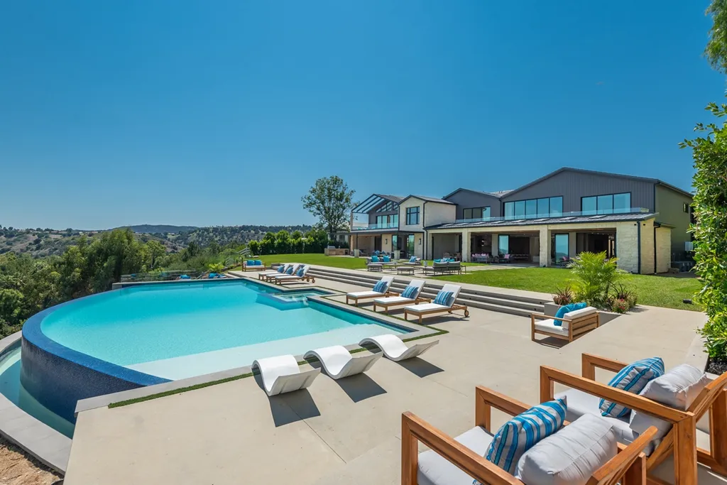 25079 Jim Bridger Road Home in Calabasas, California. Discover the epitome of refined luxury in this stunning new estate on a beautiful 1.6-acre lot in Hidden Hills. The open floor plan features a chef's kitchen, butler's pantry, and expansive great room with sliding walls of glass. Enjoy amenities like a home theater, large game room, and an oversized gym & spa.